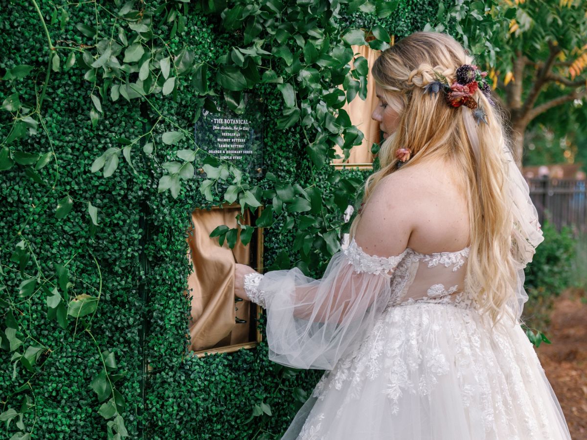 Bride in front of a custom fabricated drink wall